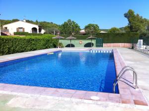 a swimming pool with blue water in a yard at Casa d'Or in L'Estartit