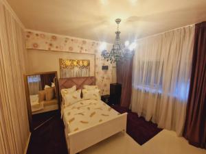 ein Schlafzimmer mit einem weißen Bett und einem Kronleuchter in der Unterkunft Romana Studio in Bukarest