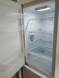 um frigorífico vazio com a porta aberta numa cozinha em Le Grand Montjoux em Besançon