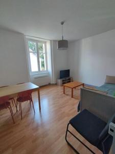 uma sala de estar com um sofá e uma mesa em Le Grand Montjoux em Besançon