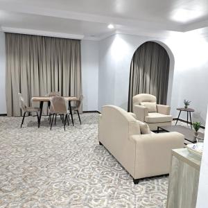 شقق الكوثر الفندقية في مكة المكرمة: غرفة معيشة مع كراسي وطاولة طعام