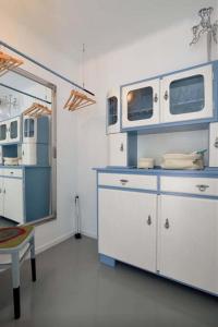 una cucina con armadi blu e bianchi e uno specchio di Apartment A.M.P. a Pola (Pula)