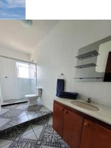 a bathroom with a sink and a toilet at Apartamento Grande em Itapuã - Vila Velha in Vila Velha