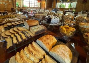 una mesa cubierta con muchos tipos diferentes de pan en Fazenda Santa Rita Turismo Rural, en Bom Jardim da Serra