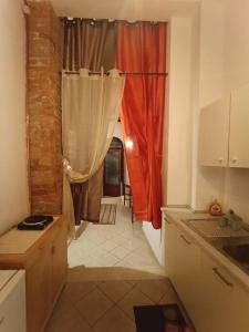 a kitchen with red curtains and a hallway with at Appartamento Maria in Siena