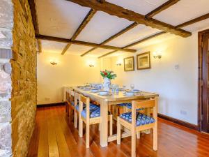 una sala da pranzo con tavolo e sedie in legno di 5 Bed in Brecon BN038 a Llanspyddid