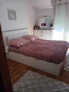 1 dormitorio con 1 cama con manta morada y espejo en Sunset Rooms Dubrovnik, en Dubrovnik