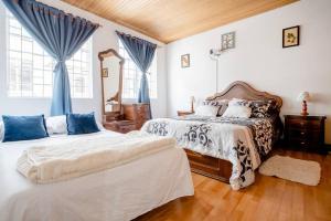 2 camas en un dormitorio con cortinas azules en Samor centro histórico Bogota, en Bogotá