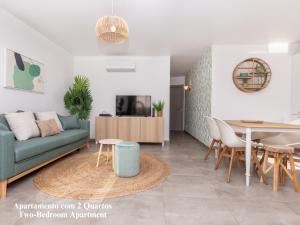 een woonkamer met een bank en een tafel bij Akisol Albufeira Breezy in Olhos de Água