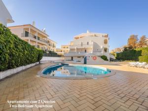 a courtyard with a swimming pool in front of a building at Akisol Albufeira Breezy in Olhos de Água