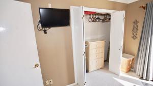 - une chambre avec un placard et une télévision murale dans l'établissement 3 Palms West, à Gulf Shores