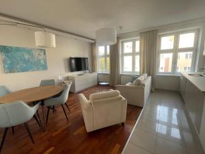 Il comprend un salon avec une table et des chaises ainsi qu'une cuisine. dans l'établissement Apartament w centrum Gdańska, à Gdańsk