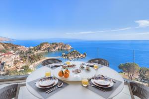 タオルミーナにあるPuravista Luxury Homeの白いテーブル(海の景色を望む皿付)