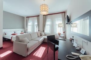 uma sala de estar com um sofá branco e uma cama em Boutique Hotel Palais Royal em Odessa