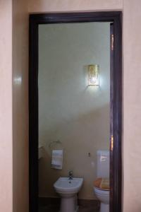 Eden Palm Resident Palmeraie Marrakech في مراكش: حمام به مرحاض أبيض ومغسلة