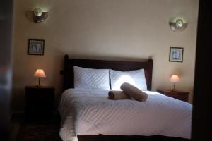 Eden Palm Resident Palmeraie Marrakech في مراكش: غرفة نوم بسرير مع شراشف بيضاء ومصباحين