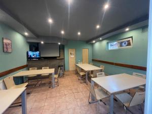 a room with tables and chairs and a flat screen tv at Pensiunea Morosanu in Borşa