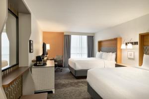 a hotel room with two beds and a desk at Doubletree By Hilton Fort Worth South in Fort Worth