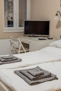 1 Schlafzimmer mit 2 Betten und einem TV auf einem Schreibtisch in der Unterkunft RoomBack Rooms - 2BR Apt with AC near Deak ter in Budapest
