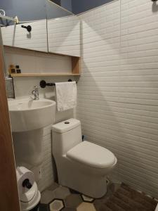 a bathroom with a white toilet and a sink at Samor centro histórico Bogota in Bogotá