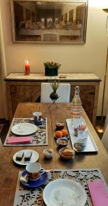 una mesa de madera con platos y cuencos de comida. en B&B A Casa Tua, en Asís