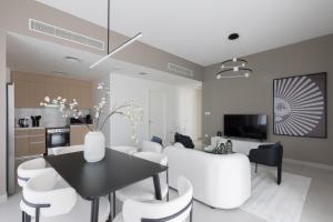 a living room with a table and white chairs at Creek Beach Roomy 3BR + terrace in Dubai