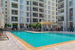 a large swimming pool in front of a building at Creek Beach Roomy 3BR + terrace in Dubai