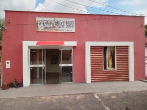 um edifício vermelho com um sinal na lateral em Pousada águas belas em Carolina