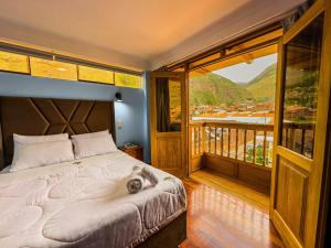 una camera da letto con un letto grande e un balcone di Pisonay Hotel a Písac