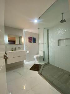 a white bathroom with a shower and a sink at Marina del Sol Resort Condo directly on the Ocean 102 in Mazatlán +52 photos