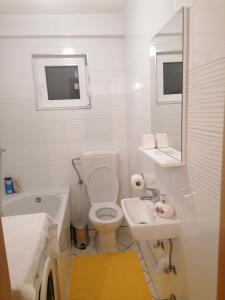 een witte badkamer met een toilet en een wastafel bij Bevanda in Široki Brijeg