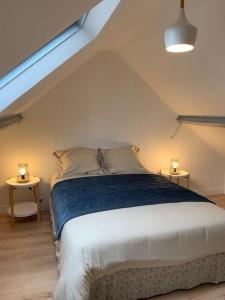una camera da letto con un letto con due luci su due tavoli di Les Falaises d'Albâtre a Heuqueville