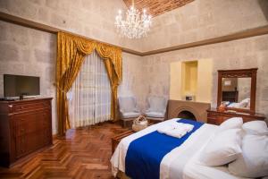 a bedroom with a large bed and a chandelier at Hotel Casona Solar in Arequipa