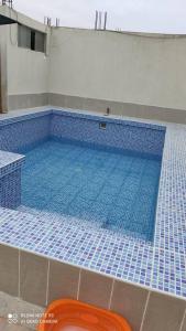 uma grande piscina com piso em azulejo azul em Casa de playa Camana (DUPLEX) em Camaná