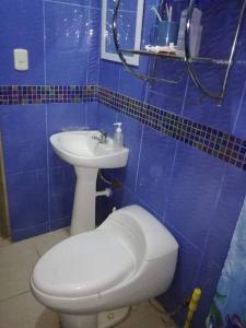 Baño de azulejos azules con aseo y lavamanos en Casa de playa Camana (DUPLEX), en Camaná