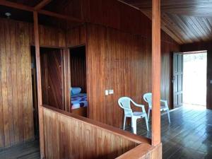Camera in legno con 2 sedie e un tavolo di Casa Miramar a Uvita