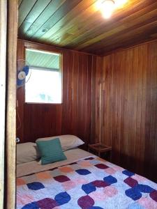 1 dormitorio con 1 cama en una habitación con ventana en Casa Miramar en Uvita