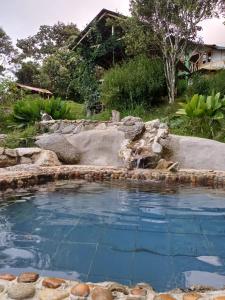 una piscina de agua con rocas en un patio en Ecofinca in the mountains Azulita House en Cocorná