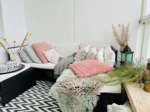 een woonkamer met een bank met kussens erop bij Modern and cosy 3-bedroom apartment with private sauna, in trendy Kalasatama in Helsinki