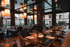 a restaurant with tables and chairs and windows at Boutique Hotel Palais Royal in Odesa