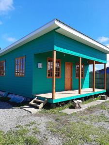 a small green house with a blue at Cabañas de Campo MARBAJA in Puerto Montt