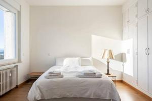 a white bedroom with a bed with two towels on it at Madrid Executive Bright y Central in Madrid