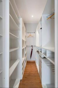 a white walk in closet with white shelves at Madrid Executive Bright y Central in Madrid