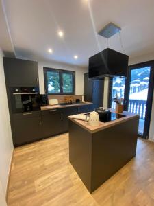 a kitchen with black cabinets and a counter top at Appartement PISTE ROUGE in Les Houches