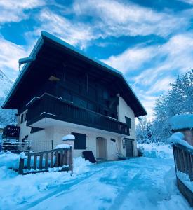a house with snow on the ground in front of it at Appartement PISTE ROUGE in Les Houches