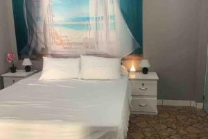 a bedroom with a white bed and two night stands at Rancho Blue Honeymoon in Acajutla