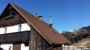 ツェルクニェ・ナ・ゴレニスケムにあるApartments Relax Jezercaの山褐色の屋根の木造納屋