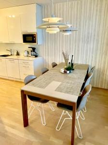 een eettafel en stoelen in een keuken bij Modern and cosy 3-bedroom apartment with private sauna, in trendy Kalasatama in Helsinki
