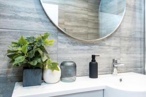 a bathroom with a sink and a mirror at Granby Gem: Exquisite 3-Bed Flat in Harrogate +41 photos