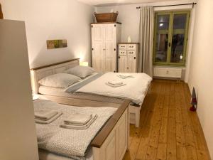 2 camas individuais num quarto com pisos em madeira em Apartmán č.2 em Banská Štiavnica